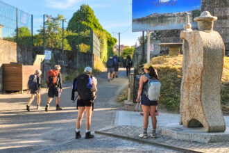 10072026 Peregrinos na rua Olimpicos Tudenses xunto a nova escultura de Rai